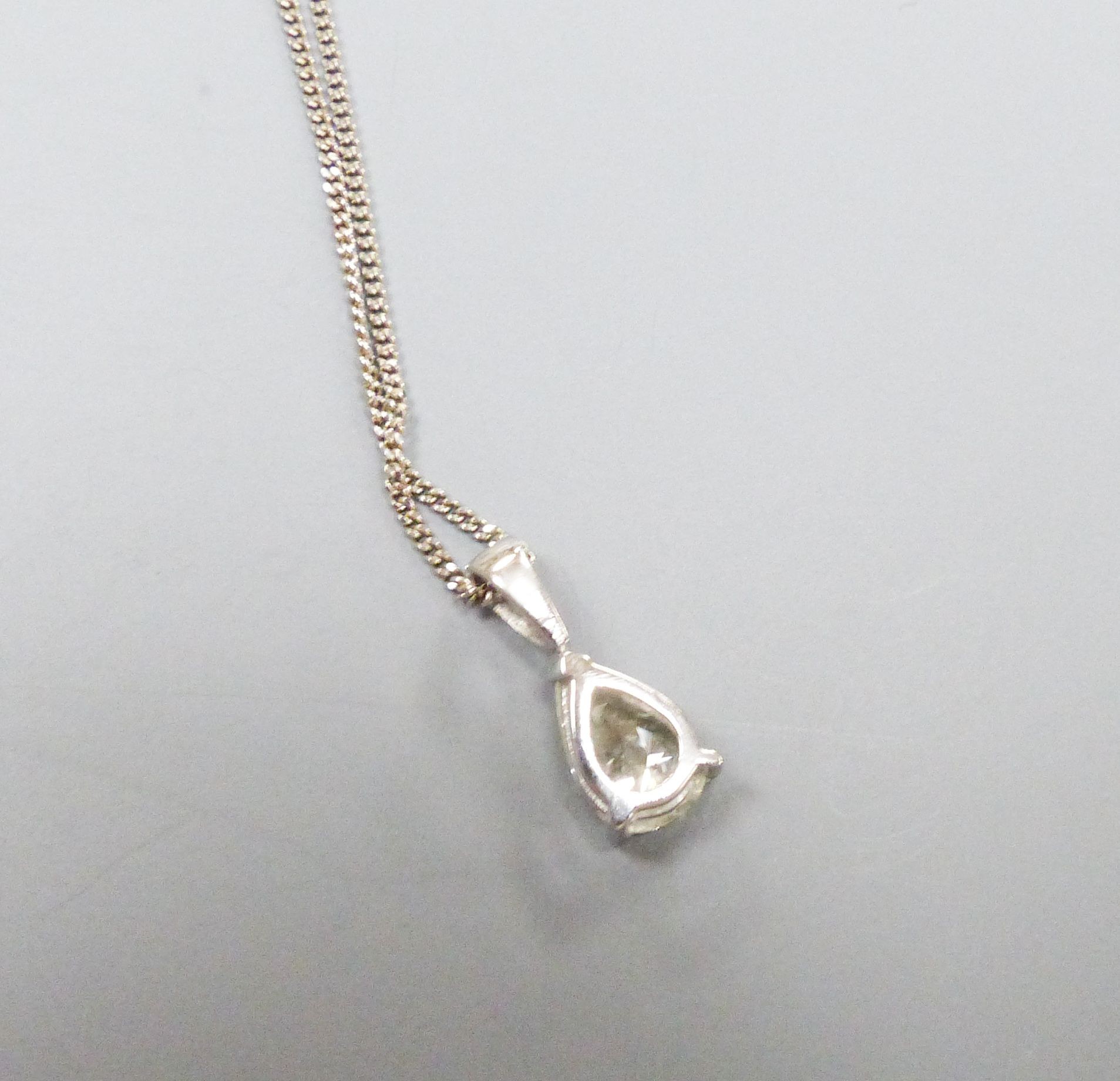 A modern white metal and solitaire pear shaped diamond set pendant, overall 14mm, on and 18ct white gold fine link chain, 40cm, gross weight 2.9 grams